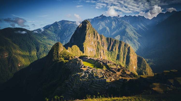 Panoramic view of Machu Picchu Inca ruins in Peru with terraces, temples, and surrounding green Andes mountains